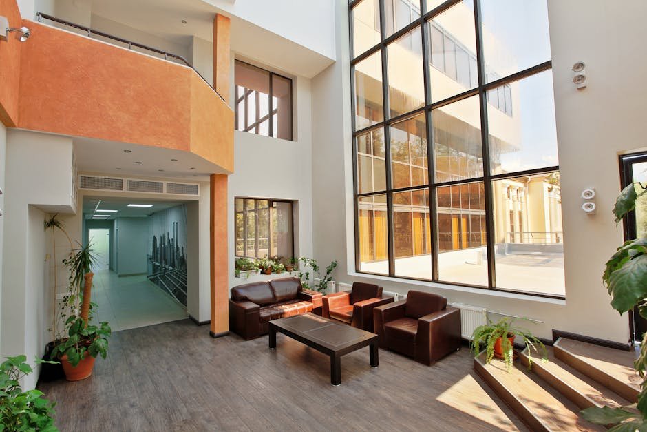 Hall d'accueil d'immeuble tertiaire moderne, plafond haut, larges baies vitrées et mobilier contemporain