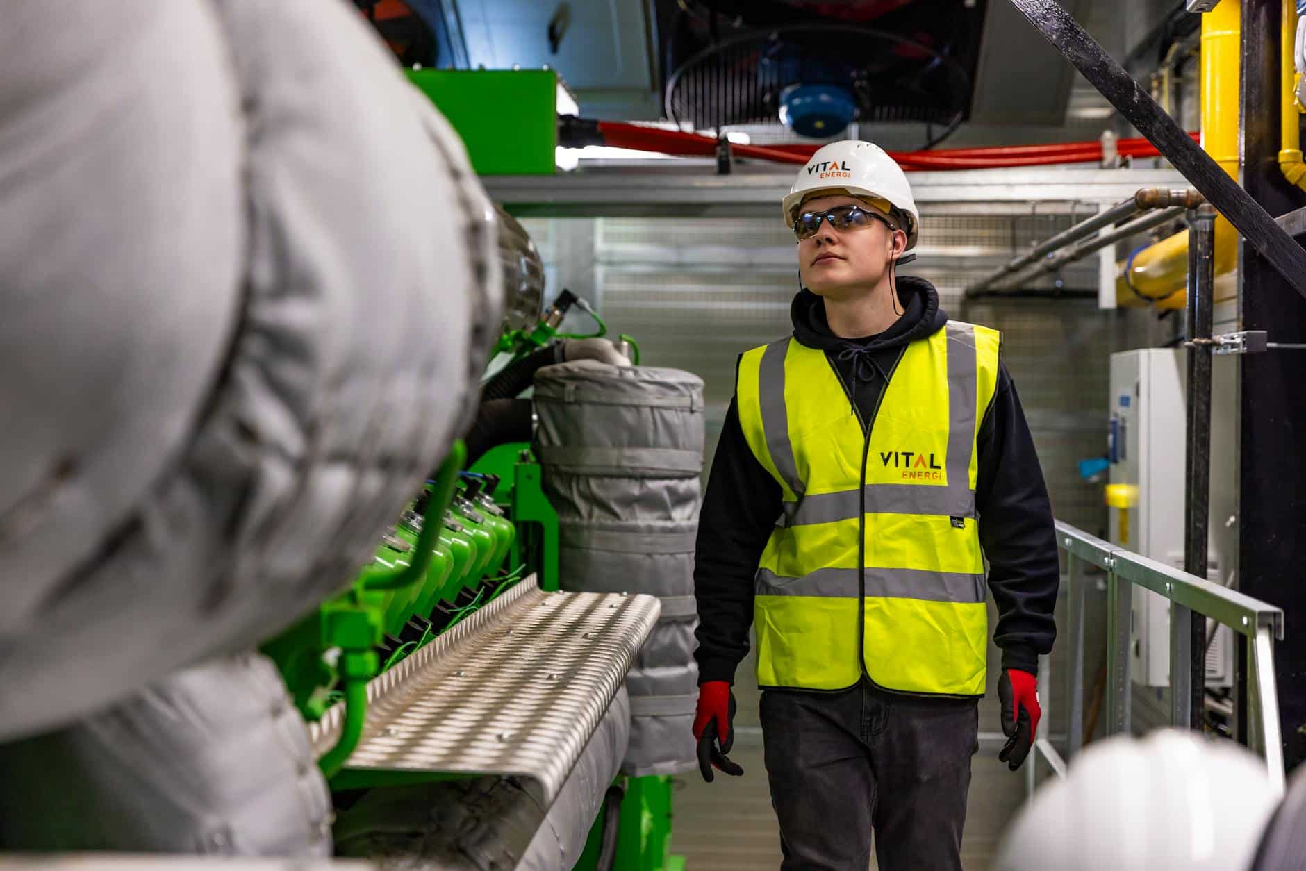 Technicien en EPI examinant une machine industrielle, exemple de travailleur isolé